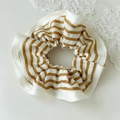Gedetailleerde weergave van gestreepte bruin-witte scrunchie met elegante satijnen rand - Gele Rand Gestreepte Klein