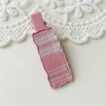 Detail of pink plaid fabric inlay on a wavy metal hair clip with a soft lace background - Square Style