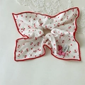 Detailed shot of cherry print scrunchie with red bow and heart charm decoration - Square Scarf Bow