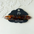 Detailed macro view of tortoiseshell acetate hair clip on brand cloud display card - Glazed Multi-color