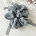 Close-up of elegant grey-blue puff gauze scrunchie with long ribbon and texture details - Gray