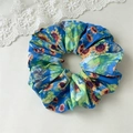 Dettaglio del grande elastico per capelli in raso blu con stampa di girasoli - Girasole Blu
