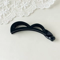 Detail eines glänzenden schwarzen Bananen-Haarclips mit hohlem Doppelbogendesign - Hellschwarz