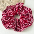 Detailed view of large paisley pattern fabric scrunchie with classic red and white bandana print - Red