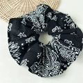 Detail of large black scrunchie with white paisley pattern on beige background - Black