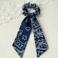Detail von marineblauem Haargummi mit Paisley-Muster und eleganten langen Bändern - Marineblau