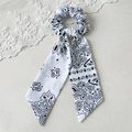 Detailaufnahme eines weißen Scrunchies mit Paisley-Muster, langen Bändern und Spitze - Weiß