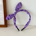 Detailopname van paarse Halloween-hoofdband met konijnenoren en Boo-patroon op wit - Paarse Schedel
