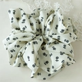 Detail view of cream floral scrunchie featuring premium chiffon fabric and elegant pleats - White Floral Style B