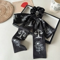 Details des eleganten schwarzen Satin-Haarbandes mit floraler Skizze und langen Bändern - Schwarze Skizze Band