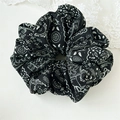 Detaillierte Draufsicht auf ein schwarzes Paisley-Stoff-Haargummi mit Spitzenakzent - Schwarz Paisley Stil C