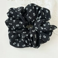 Detail of floral scrunchie with white flower patterns on black soft fabric - Black Floral Style B
