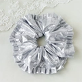 Nahaufnahme eines silbernen Scrunchie mit metallischem Glanz und plissierter Textur - Silber Laser Großer Kreis