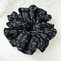 Dettaglio di un elastico per capelli con rose bianche su tessuto in chiffon nero - Ciondolo a rosa nera