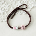 Close-up of hair tie with cute kitten in checkered shirt and small pink fish pendant - Pink Kitten + Fish