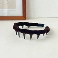 Detail of dark coffee velvet headband featuring black long plastic teeth for hair styling - Brown