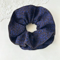 Dettaglio di scrunchie con stampa floreale a macchie blu e bordo rifinito con cura - Pois blu