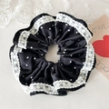 Detailaufnahme von schwarzem Polka-Dot-Satin-Scrunchie mit zarter weißer Spitzenkante - Schwarz Spitze Gepunktet
