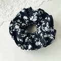 Dettaglio dell'elastico per capelli floreale bianco e nero con texture elegante - Elastico Floreale Nero