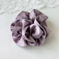 Detail shot of dusty purple satin scrunchie with pleated texture and silky metallic sheen - Pink
