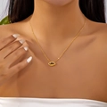 Close-up of gold Evil Eye necklace with blue gemstone on model's collarbone - Necklace (Copper)