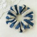 Gros plan d'un chouchou en tricot rayé bleu et blanc avec texture en laine douce - Rayé Bleu