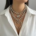 Detailaufnahme einer silbernen doppellagigen Perlenkette mit Herzanhängern am Model - Silber Stil