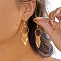 Vue détaillée de longues boucles d'oreilles dorées à pompons avec des pales en métal - Boucles d'oreilles / Doré