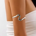 Dettaglio del bracciale da braccio ondulato argento minimalista sul braccio superiore - Stile Onda Dorata 11