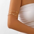Détail d'un bracelet de bras minimaliste doré à plusieurs fils porté sur le haut du bras - Style Croisé Martelé Doré (BR25Y0296-1)
