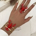 Dettaglio dell'anello con aragosta rossa e bracciale dorato indossati sulla mano del modello - Set bracciale e anello