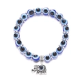 Makroaufnahme von blauen Evil Eye-Perlen und Elefantenanhänger-Armband mit silbernen Akzenten - Elefant