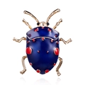 Detailed close-up of a blue and red enamel beetle brooch with gold-plated finish - Blue Beetle