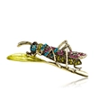 Dettaglio ravvicinato di una spilla a cavalletta dorata con strass multicolore - Cavalletta