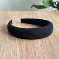 Dettaglio di un elastico per capelli in tessuto nero su una superficie in legno naturale - Cerchietto Nero