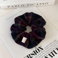 Detalle de un coletero a cuadros con etiqueta Hand Made junto a libros de arte retro - Cuadros Rojo Oscuro