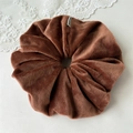 Détail d'un chouchou en velours marron rouge avec étiquette et texture douce en peluche - Marron