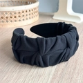 Detail of black pleated fabric headband showing the soft texture and elegant folds - Black