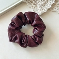 Close-up of a burgundy PU leather scrunchie with shiny vintage texture and folds - Dark Red