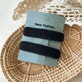 Close-up of two black twill fabric hair clips with high-elastic knit texture on card - Black Twill Duo