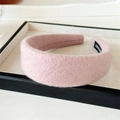 Detail shot of a pink wool headband with a handmade label and soft fiber texture - Pink