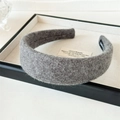 Close-up of grey wool plush headband showing handmade label and soft fuzzy texture - Gray