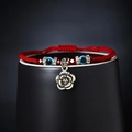 Red woven evil eye bracelet featuring blue beads and vintage silver rose pendant charms - Rose Style