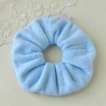 Detail of light blue towel fabric scrunchie with cute bear label and fuzzy texture - Blue