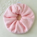 Close-up of pink plush oversized scrunchie texture with cute blue bear label detail - Pink