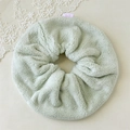 Close-up of a soft mint green plush scrunchie with a cute pink cartoon bear fabric label - Green