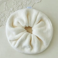Close-up of fluffy beige microfiber scrunchie with cute blue cartoon bear tag - Off White