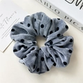 Dettaglio di elastico scrunchie in velluto grigio-blu con pois neri su fondo pulito - Elastico a Pois Velluto Blu