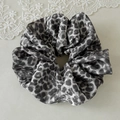 Detalle de coletero de satén con estampado de leopardo, textura suave y pliegues - Leopardo Gris