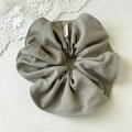 Detail of khaki fabric scrunchie with textured material and Hand Made label tag - Beige Grey